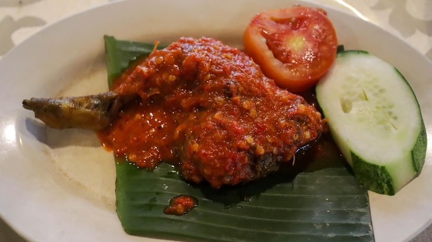 Ayam Goreng Balado to przysmak Indonezyjczyków ze smażonym kurczakiem i pikantną pastą balado Pochodzące z Zachodniej Sumatry danie zapewnia ogniste i aromatyczne doznania Podawane z ryżem i warzywami