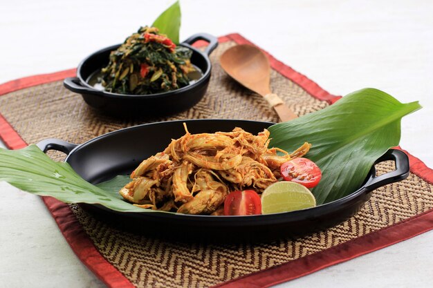 Ayam Sisit Lub Ayam Suwir To Kuchnia Balijska Z Pikantnych Kawałków Mięsa Z Kurczaka, Podawana Na Czarnym Talerzu.