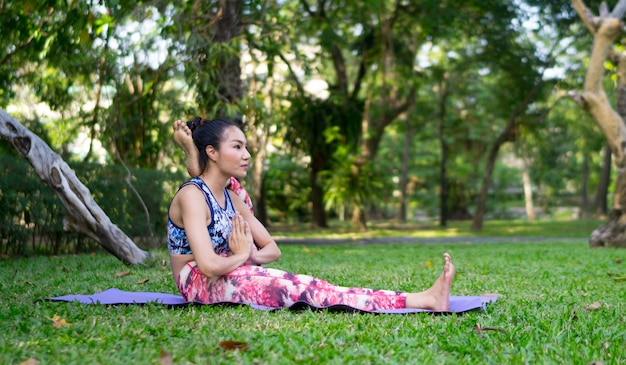 Azja kobieta robi joga pozie przy plenerowym, joga praktyki szkolenia pojęciem