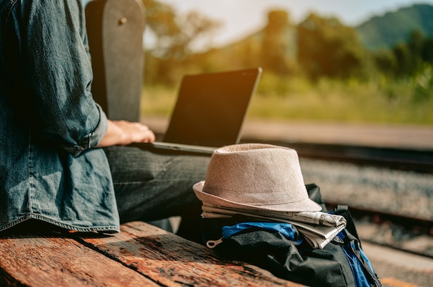 Zdjęcie azjaci używają laptopa do pracy, czekając na wejście do pociągu, aby odbyć podróżwakacyjna podróż