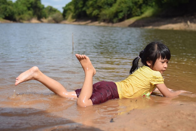 Azjatka bawi się wodą na rzece na plaży?