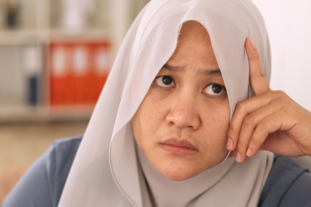 Azjatka, muzułmanka, która myśli o czymś, szuka rozwiązania problemu.