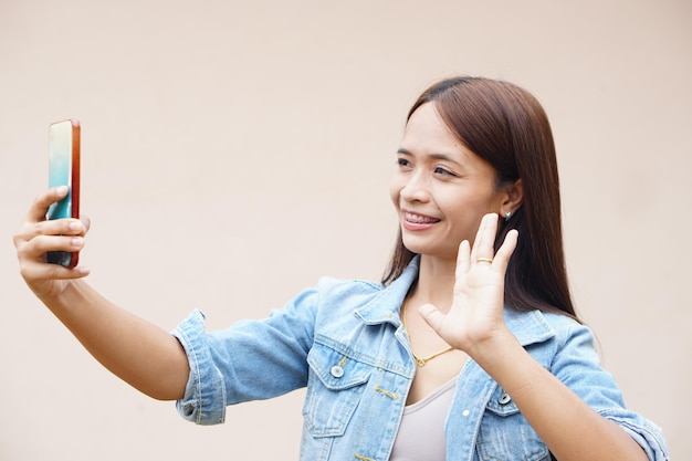 Azjatka szczęśliwie robi sobie selfie telefonem