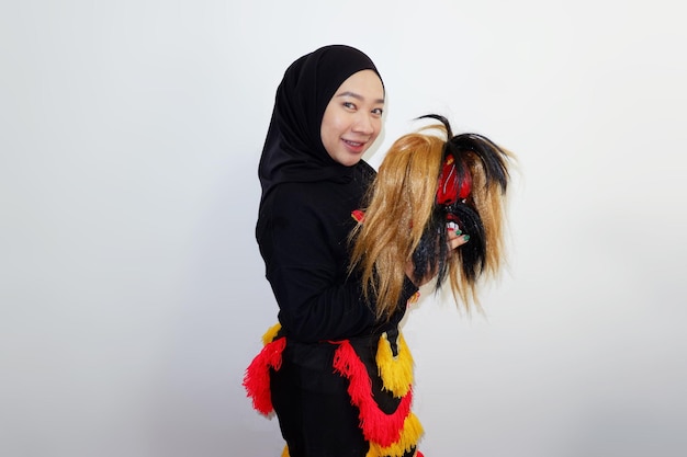 Azjatka w hidżabie trzymająca maskę Jatilan izolowaną na białym tle