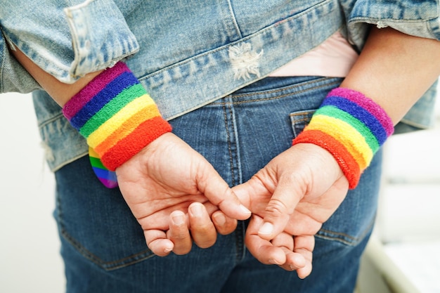 Azjatka z tęczową flagą symbolizuje prawa LGBT i równość płci Miesiąc dumy LGBT w czerwcu