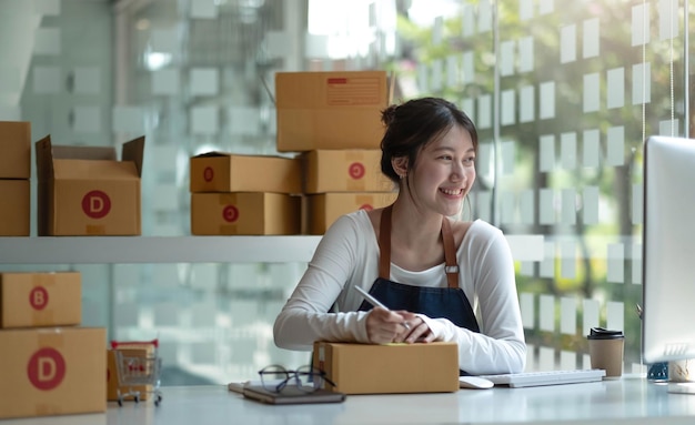 Azjatki Mały biznes przedsiębiorca MŚP piszący adres na kartonie w miejscu pracy Mały biznes przedsiębiorca MŚP pracujący z pudełkiem w domu