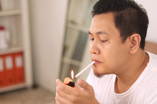 Azjaty zapala papierosa i pali bliski portret palacza