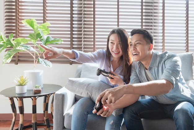 Azjatyccy miłośnicy par cieszą się i grają w gry konsolowe na wakacjach, aby spędzić więcej czasu na szczęście w domu
