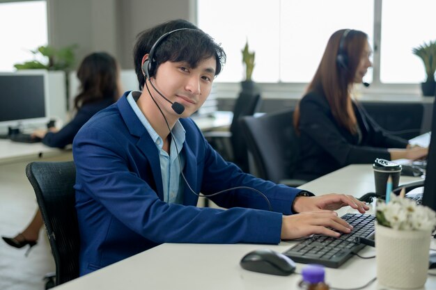 Azjatyccy operatorzy noszą słuchawki pracujące w miejscu pracy.