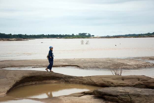 Azjatyccy podróżnicy tajska kobieta podróżuje spacerując i pozując do robienia zdjęć w Sam Pan Bok jest znany jako Wielki Kanion Tajlandii na rzece Mekong podczas pory deszczowej w Ubon Ratchathani Tajlandia