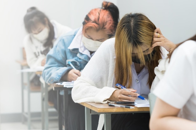 Azjatyccy studenci koncentrują się na robieniu egzaminów w klasie Edukacja Zdjęcie Stockowe