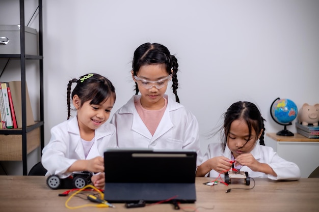 Azjatyccy studenci uczą się w domu, kodując samochody robotów i kable do tablic elektronicznych w STEM STEAM matematyka inżynieria nauka technologia kod komputerowy w robotyce dla koncepcji dla dzieci