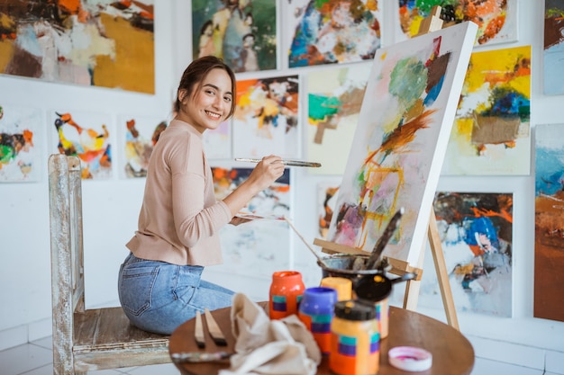 Azjatycka artystka malująca na płótnie wykonująca projekty artystyczne w swoim warsztacie studyjnym