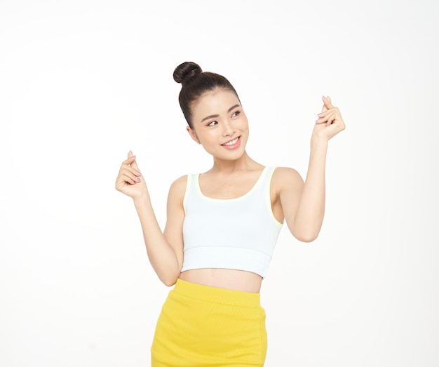 Azjatycka atrakcyjna piękna młoda kobieta z gestem ręki i uroczym wyrazem twarzy w sportowym stroju na białym tle