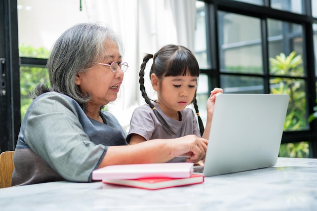Azjatycka babcia z dwójką wnuków bawi się i gra w gry edukacyjne online
