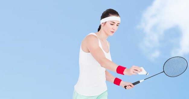 Azjatycka badmintonistka grająca przeciwko chmurom na niebieskim niebie