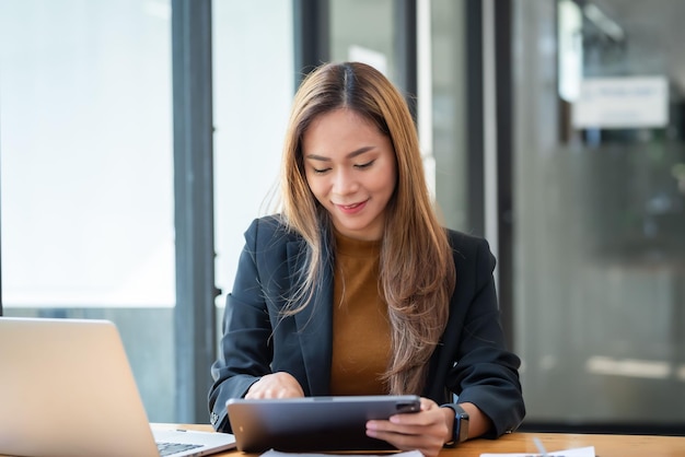 Azjatycka bizneswoman, która chętnie pracuje na tablecie