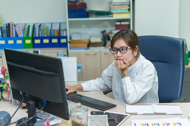 Azjatycka bizneswoman pracująca na biurku w biurzeTajlandzka kobieta pracownica uśmiechPiękna sekretarka ma fajny uśmiechKobieta urzędniczka nadgodziny w firmie