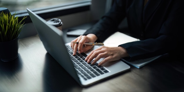 Azjatycka bizneswoman używająca laptopa do obliczania podatków i danych finansowych biznesu w biurze