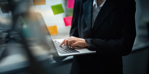 Azjatycka bizneswoman używająca laptopa do obliczania podatków i danych finansowych biznesu w biurze