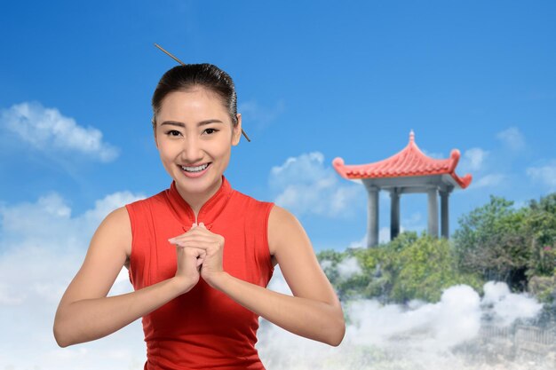 Azjatycka Chinka w sukience cheongsam z gestem gratulacji. Szczęśliwego Nowego Chińskiego Roku