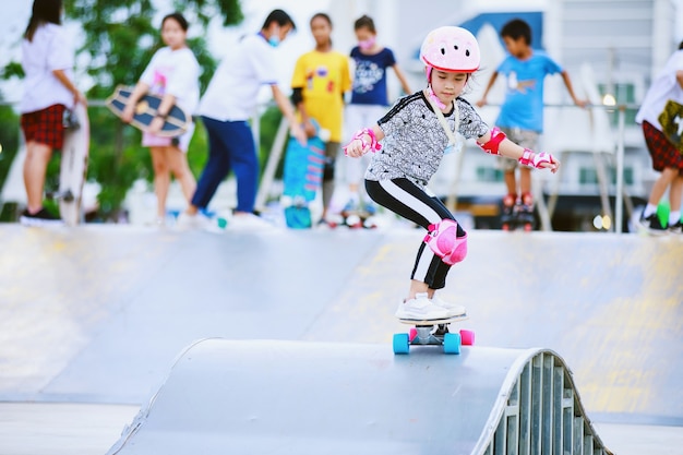 azjatycka dziewczyna jeździ na deskorolce na skate parku?