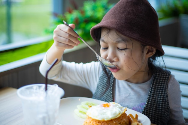 Azjatycka dziewczyna lubi jeść jedzenie na śniadanie lub lunch w restauracji
