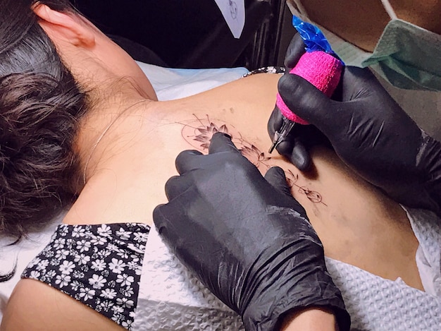 Azjatycka dziewczyna robi jej plecy tatuaż robić profesjonalnym tatuażystą