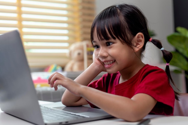 Azjatycka dziewczyna używa laptopa do nauki online nauczania domowego podczas kwarantanny domowej nauczania domowego online studium kwarantanny domowej online uczenia się koronawirusa lub koncepcji technologii edukacyjnej