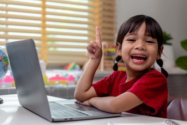 Azjatycka dziewczyna używa laptopa do nauki online nauczania domowego podczas kwarantanny domowej nauczania domowego online studium kwarantanny domowej online uczenia się koronawirusa lub koncepcji technologii edukacyjnej