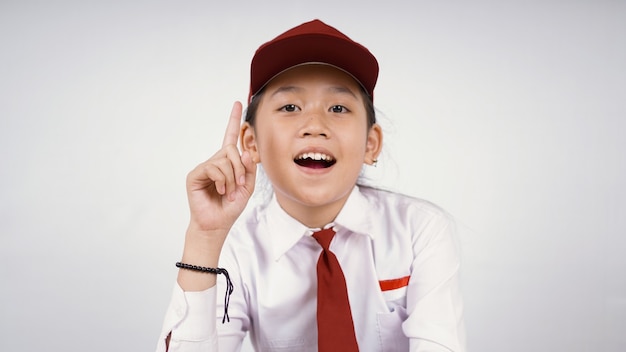 Azjatycka dziewczyna w szkole podstawowej znajduje ciekawy pomysł na białym tle