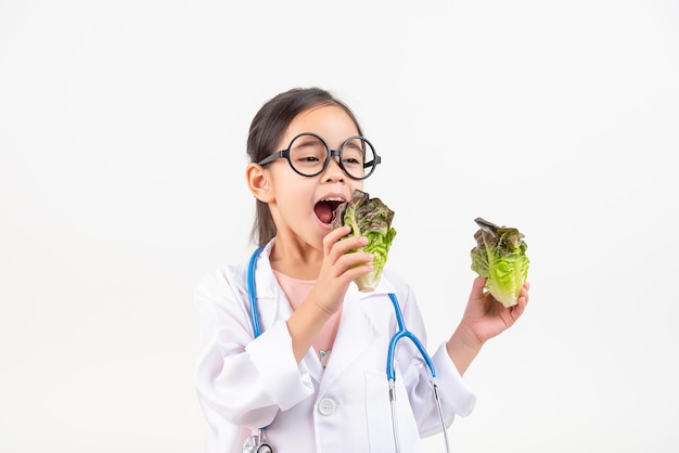 Zdjęcie azjatycka dziewczynka bawiąca się w lekarza poleca warzywa i owoce
