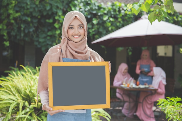 Azjatycka Kelnerka Stoi Przed Kawiarnią I Trzyma Pustego Chalkboard