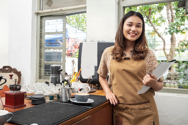 Azjatycka kobieta barista trzyma książkę menu