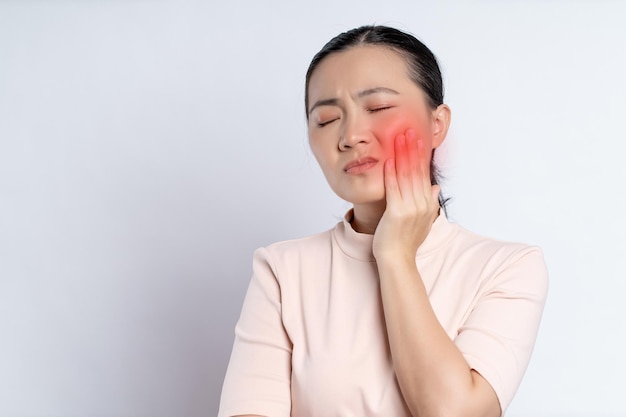 Zdjęcie azjatycka kobieta była chora na ból zęba stojąc na białym tle