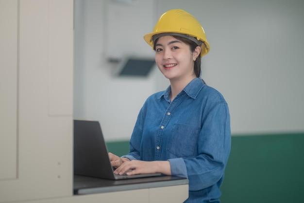 Azjatycka kobieta jest inżynierem fabryki kontrolującym maszynę w fabryce z komputerem Azjatycka kobieta inżynier pracuje w koncepcji fabryki