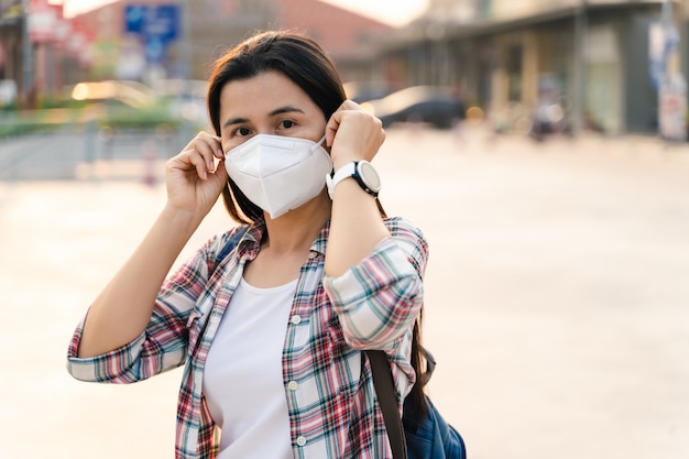 Azjatycka kobieta jest ubranym twarzy maskę w celu ochrony wirusa. Koncepcja koronawirusa COVID-19.