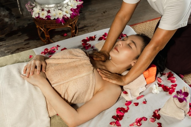 Azjatycka kobieta korzystająca z masażu peelingiem solnym w spa Opieka zdrowotna spa i masaż tajski koncepcja Dziewczyna otrzymująca holistyczny zabieg masażu tajska masażystka kobieta dostaje masaż