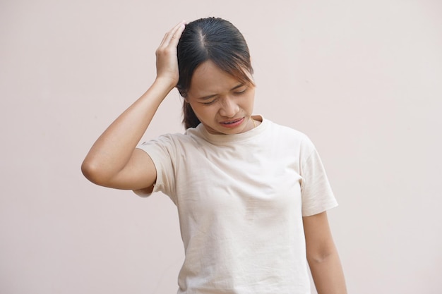 Azjatycka kobieta ma ból głowy z ciemnymi pachami