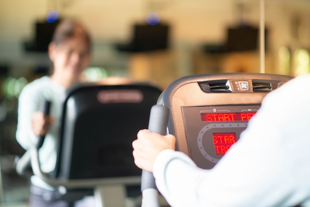 Azjatycka kobieta opracowywał ćwiczenie przy Gym odchudzaniem