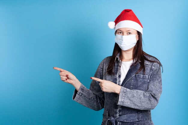 Azjatycka kobieta palcami wskazującymi nosząca medyczną maskę ochronną przed punktami wirusa