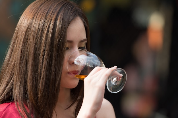 Azjatycka kobieta pije szkło alkoholu napój przy noc barem.