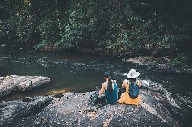 Azjatycka kobieta podróżuje wygląda na rzekę i mały wodospad w górach, koncepcja lato relaks wolność na świeżym powietrzu przyroda wakacje wakacje podróż