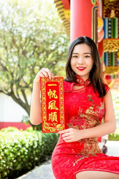 Azjatycka kobieta pokazuje Chińskiego nowego roku powitania teksta znaka