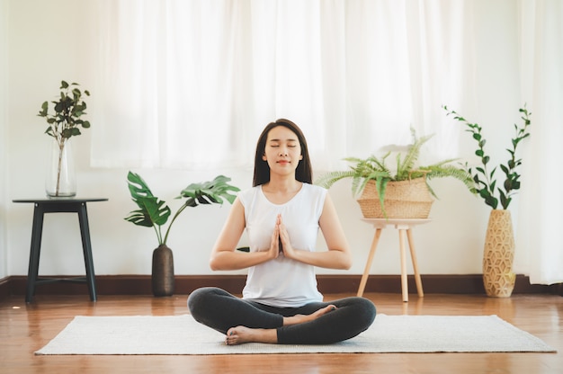 Azjatycka kobieta robi joga medytaci w domu