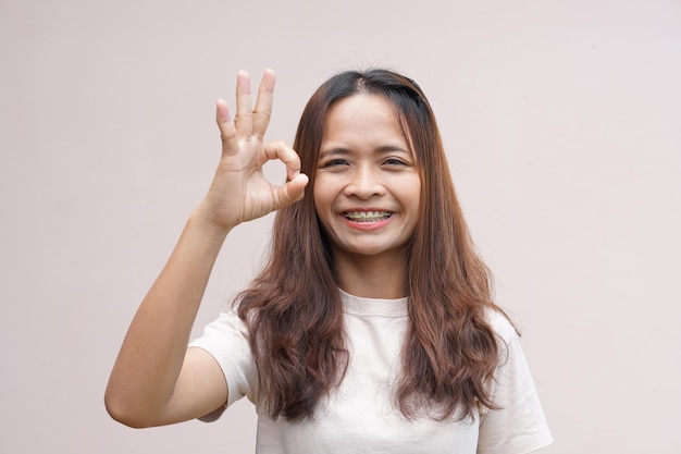 Azjatycka kobieta robi znak ręką ok