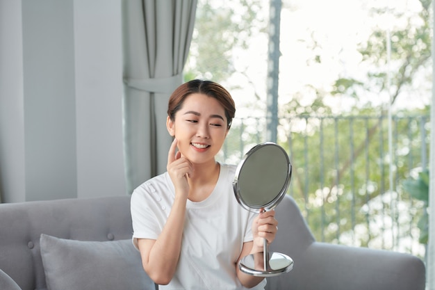 Azjatycka kobieta siedzi makijaż przed lustrem