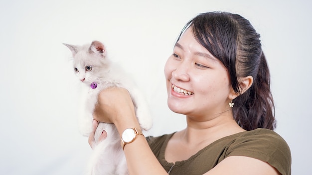 Azjatycka kobieta trzyma kota śmiejącego się na białym tle