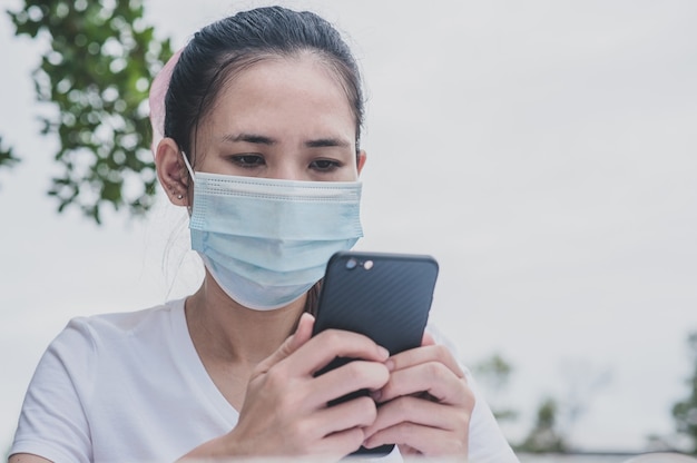 Azjatycka Kobieta Trzyma Telefon Z Maską Na Twarzy