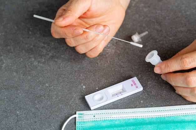 Azjatycka Kobieta Trzyma Waciki Po Trzymaniu Próbki W Plastikowej Probówce. Zestaw Testowy Do Sprawdzania Koronawirusa.